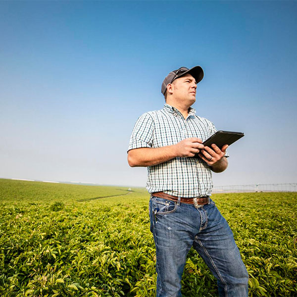 Man Standing in Field using Irrigation Control Technology
